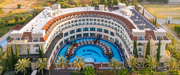 Blick von oben auf das 5-Sterne Hotel Meder Resort umgeben von Palmen, in der Mitte ein traumhafter Pool.