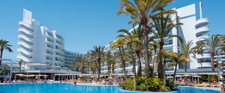 Die Außenansicht des Riu Papayas in Playa del Inglés auf Gran Canaria zeigt eine moderne Hotelanlage unter sonnigem Kanarenhimmel.